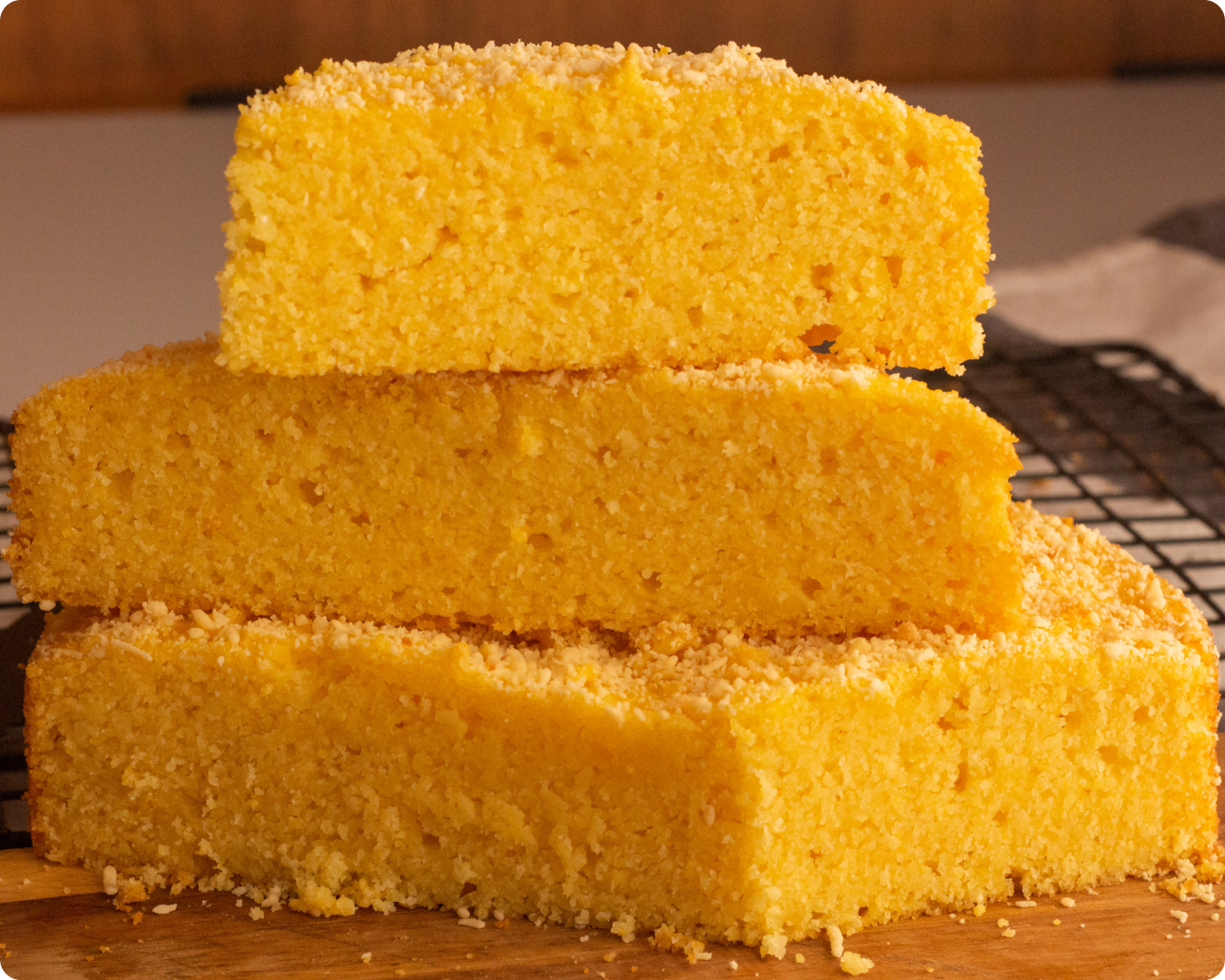 a vista interna de um bolo de fubá cortado em três partes para visualizar a maciez e umidade dessa receita de bolo de fubá que é incrível